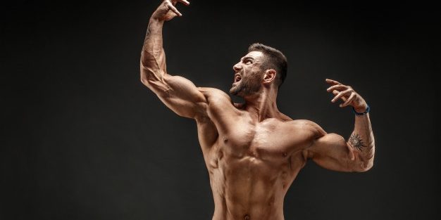 bodybuilder-posing-fitness-muscled-man-dark-wall_136403-1029